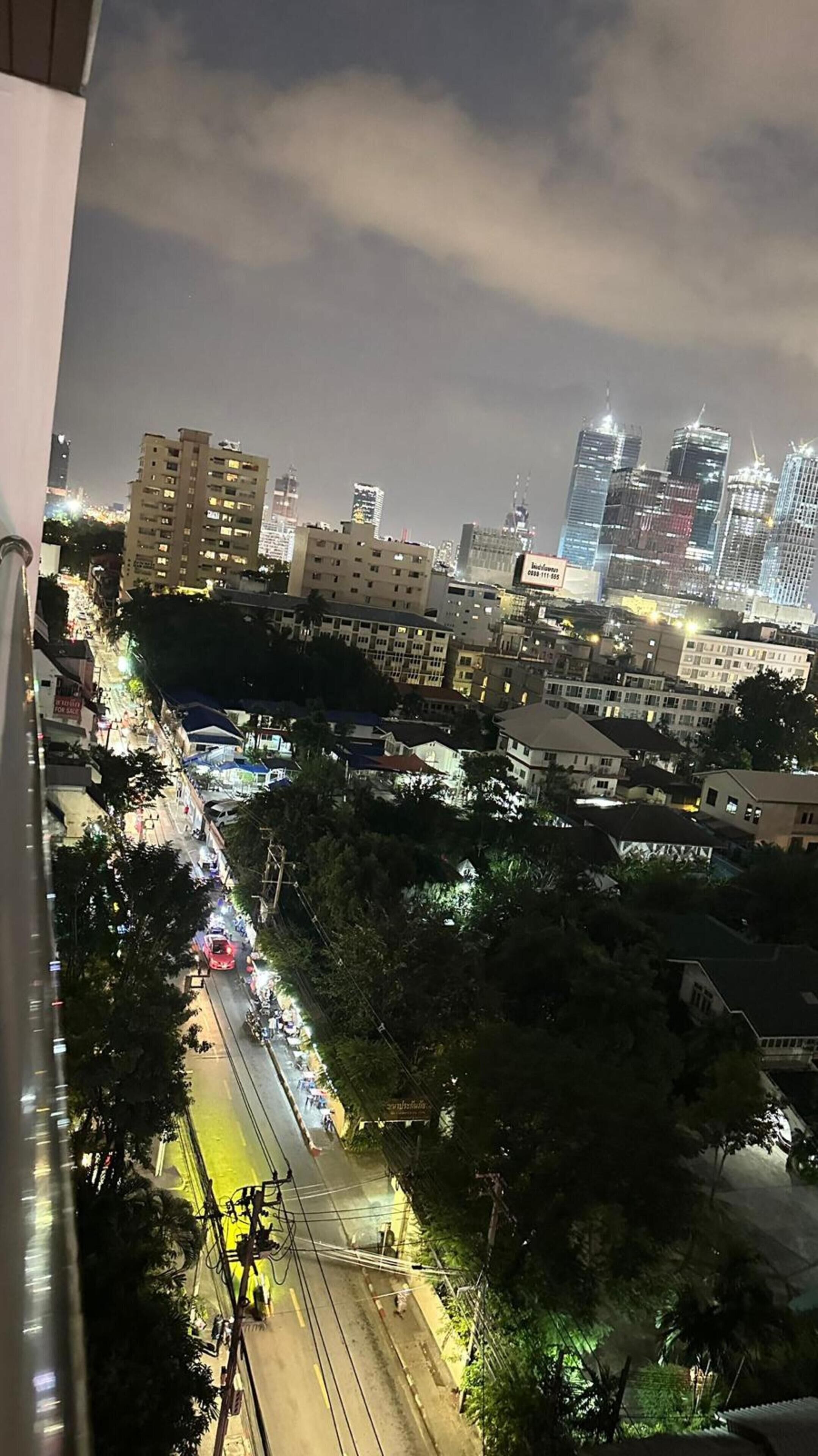 Eine beleuchtete Stadtlandschaft bei Nacht mit belebter Straße.