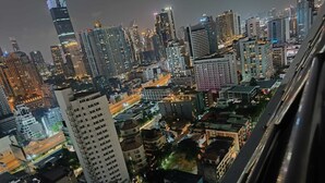 A nighttime cityscape with high-rise buildings and illuminated windows. - Omni Tower Sukhumvit Nana - Direct (Bangkok)