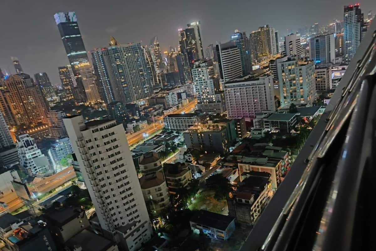 A nighttime cityscape with high-rise buildings and illuminated windows.