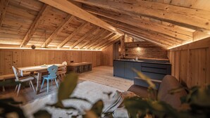 Een houten interieur met een eethoek, keuken en zithoek.