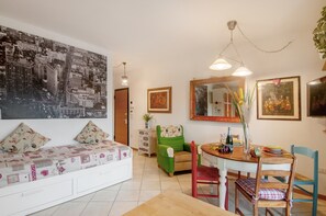 Ein Essbereich mit Tisch, Stühlen, einer Couch und einem großen Stadtbild an der Wand.