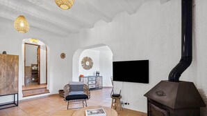 Een woonkamer met een open haard, een bank, een salontafel en een televisie.