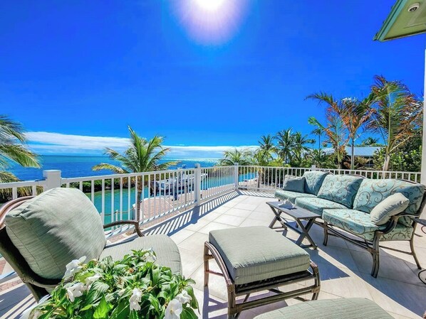 A balcony with a view of the ocean, a pool, and outdoor furniture. - The Come Back Shack on the Ocean in Duck Key with Pool and loads of privacy 2 kayaks included (Duck Key)
