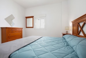 A bedroom with a bed, dresser, mirror, window, and nightstand. - Vacation Home 'Mela' with Balcony and Wi-Fi (Puerto del Rosario)