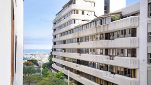 Un edificio de varios pisos con balcones, ventanas amplias y unidades de aire acondicionado.