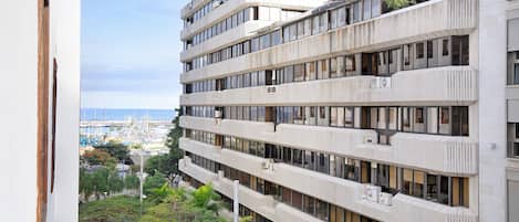 A multi-story building with balconies, large windows, and air conditioning units.