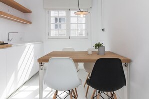 A modern kitchen with white cabinets, a wooden countertop, and a window with blinds. - Holiday Apartment 'La Alameda' with Sea View, Wi-Fi, and Air Conditioning (Santa Cruz de Tenerife)
