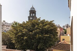 Un edificio con una torre de reloj, rodeado de árboles y otros edificios.