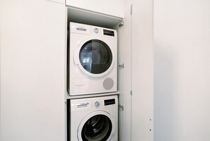 Dos lavadoras Bosch apiladas en un cuarto de lavado blanco.