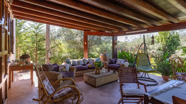 An outdoor patio with wicker furniture, a swing chair, and a view of trees. - Villa 'Il Melograno' with Private Terrace,  Jacuzzi, Wi-Fi and Air Conditioning (Menfi)