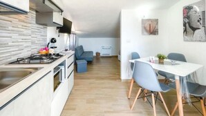 Une cuisine moderne avec un coin repas, un canapé et des œuvres d’art accrochées aux murs.