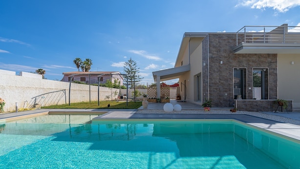 A modern house with a swimming pool, a covered patio, and a stone facade. - Apartment 'Sud In Villa Sele' with Sea View, Wi-Fi and Air Conditioning (Fontane Bianche)