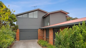 A modern two-story house with a garage, brick exterior, and a red roof. - Roadknight Ocean Road View 236 400m to Beach (Anglesea)