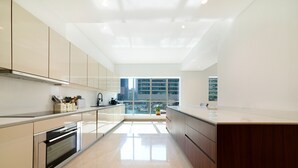 Una cocina moderna con un amplio ventanal, electrodomésticos de acero inoxidable y un diseño minimalista.