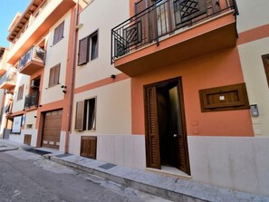 A multi-story residential building with balconies, wooden shutters, and a street in front. - Apartment Sole by Interhome (Balestrate)