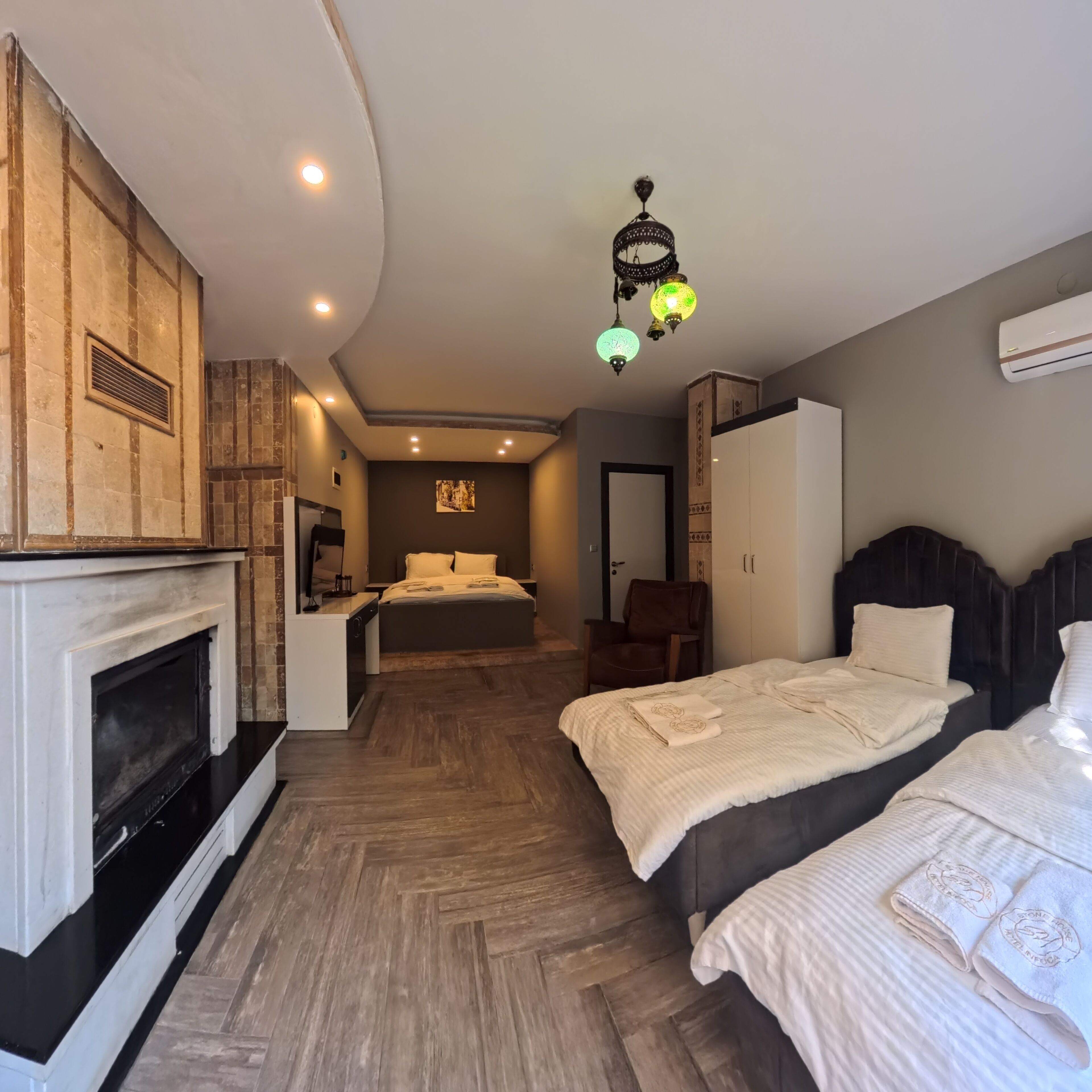 Un dormitorio con chimenea, una cama, una silla y un armario.