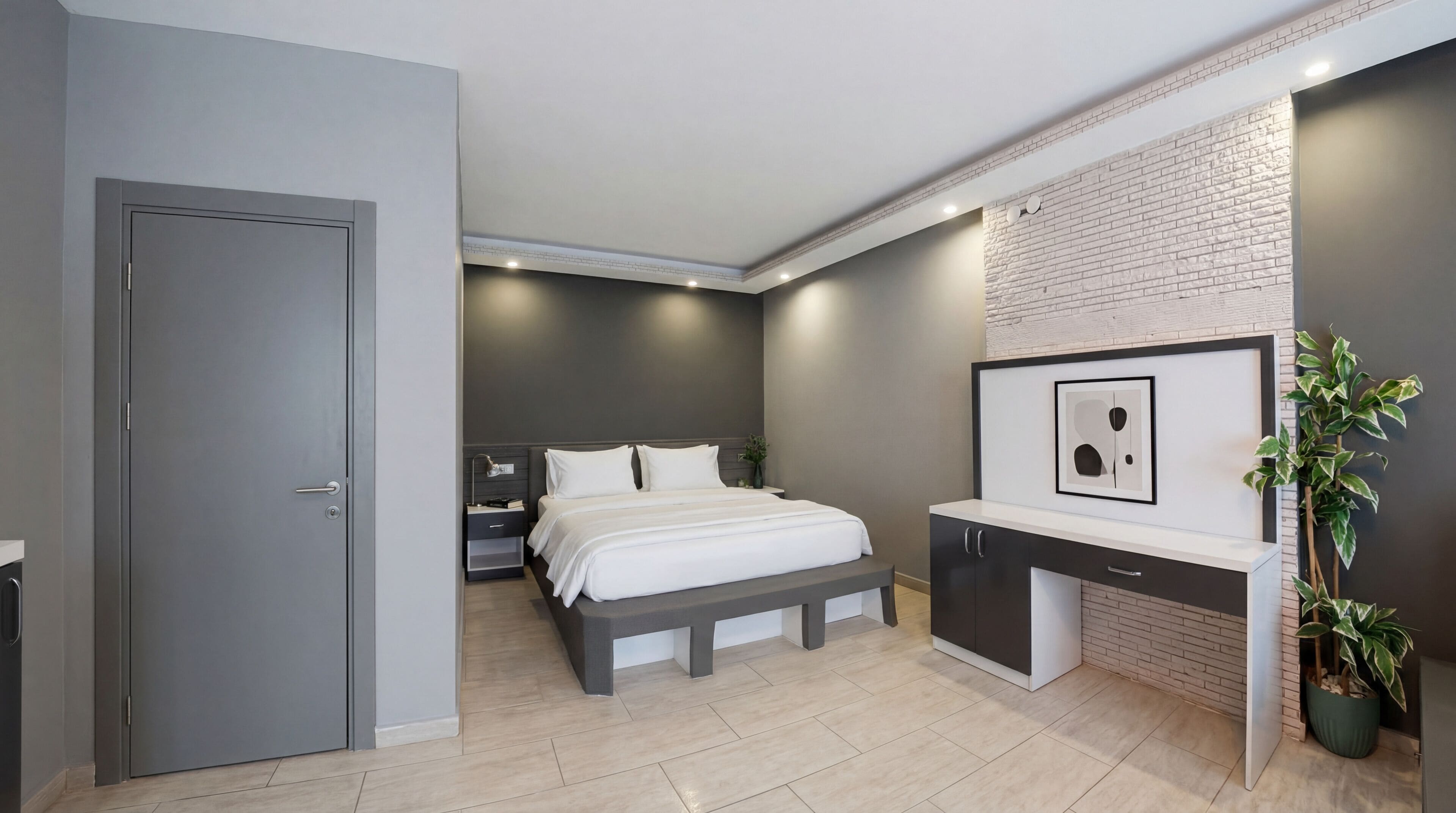 A modern bedroom with a bed, bedside table, and a built-in desk with a mirror.