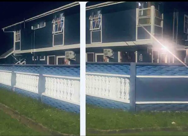 Un immeuble à étages, doté de grandes fenêtres et d’un balcon.
