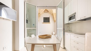 Una cocina moderna con armarios blancos, un microondas y un cesto de madera sobre la mesa.