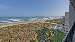 Uitzicht op het strand en de oceaan vanaf een balkon.
