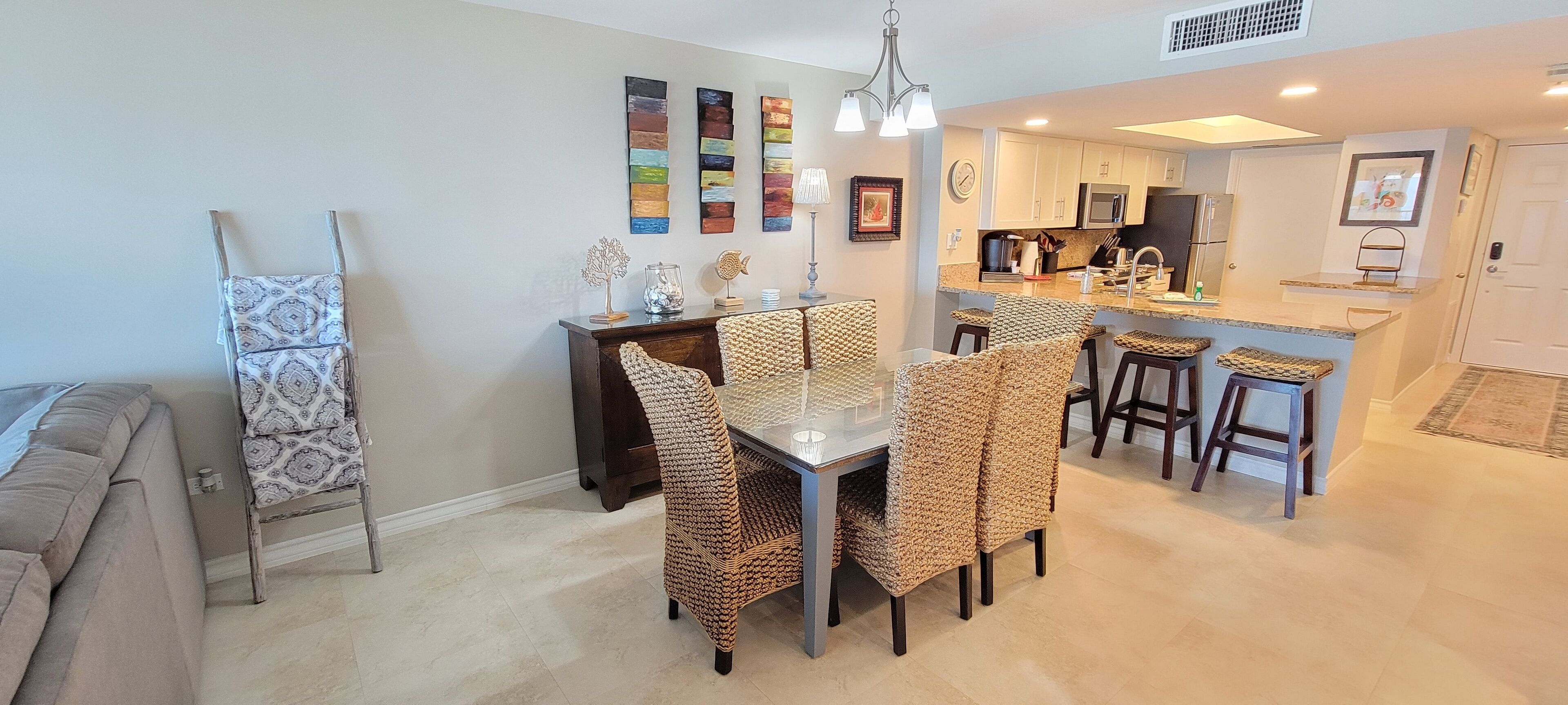 A modern kitchen with white cabinets, a stainless steel refrigerator, and a built-in oven.
