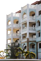 Un hotel de varios pisos con balcones y ventanas de arco.