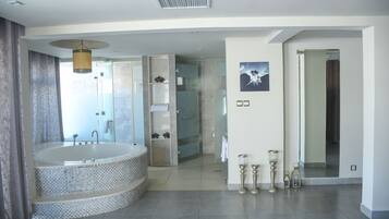 Un baño moderno con una bañera independiente grande, cabina de ducha con vidrio y un diseño minimalista.