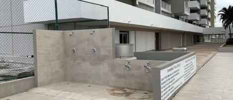Ein modernes Gebäude mit Betonfassade, mehreren Balkonen und einer Schautafel.