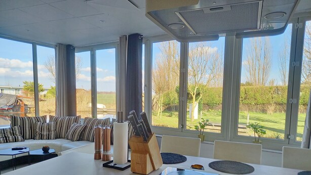A modern kitchen with a large island, a dining area, and a view of the countryside. - Pura Vida del Rio : Enjoy life ! (Oud Ade)