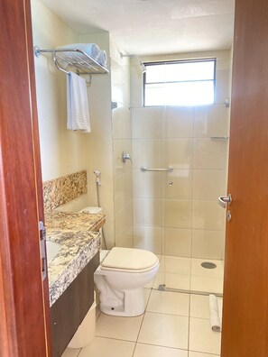 A small bathroom with a toilet, a shower, and a sink. - Apts em Quality suites (Natal)