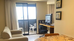 Une pièce comprenant un canapé, une table à manger avec des chaises, un téléviseur et des œuvres d’art accrochées au mur.