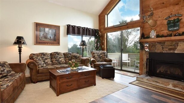 A living room with a fireplace, a large window, and a couch. - Seven Springs 3 Bedrooms Premium Condo by RedAwning (Champion)
