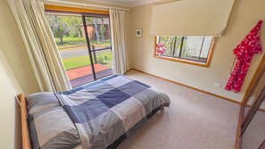 Relax in this serene bedroom with a large bed and a window offering a view of the outdoors.