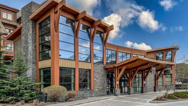 A modern building with large windows and a covered entrance area.
