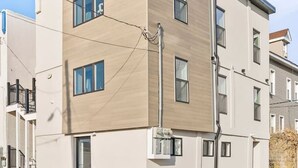 Un edificio moderno de varios pisos con techo plano, ventanas amplias y un poste de servicios visible.