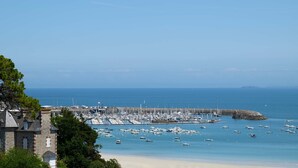 A coastal marina with boats, a sandy beach, and a stone building. - Renovated villa in park, very large sea view, 5 minutes walk from the beach (Saint-Cast-le-Guildo)