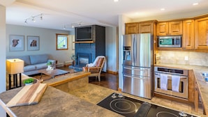 A modern kitchen with a built-in stove, stainless steel appliances, and wooden cabinets. - The Summit | Nature Lovers Dream! Family Friendly (Vernon)