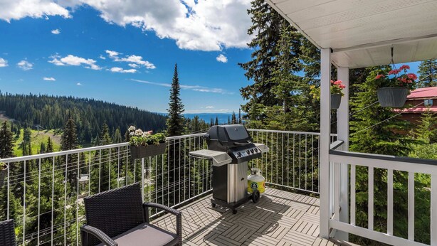 A balcony with a grill, wicker furniture, and a view of a forested area. - The Summit | Nature Lovers Dream! Family Friendly (Vernon)