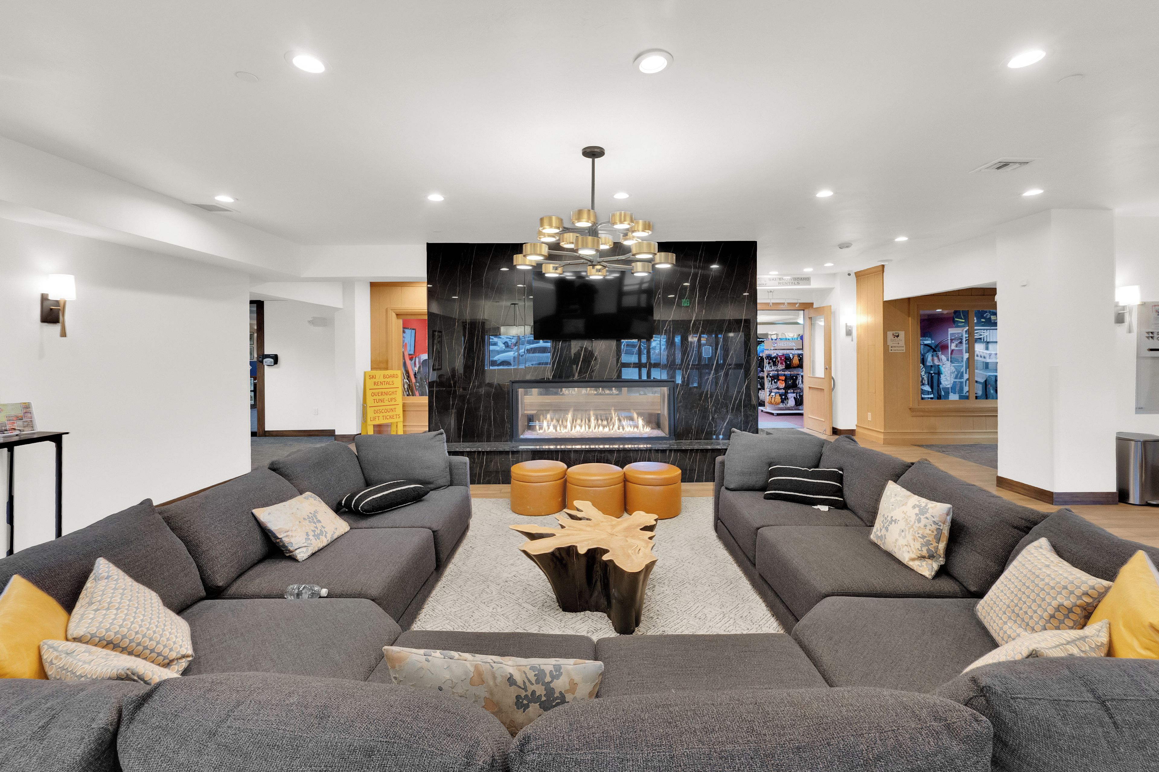 A modern living room with a fireplace, two grey sofas, and a central coffee table.