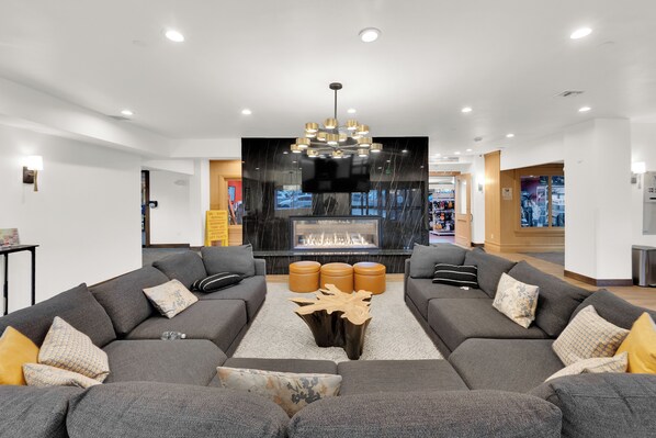 A modern living room with a fireplace, two grey sofas, and a central coffee table. - Stay next to Park City Resort! Rebuilt 2BR, 2BA Condo, MODEL PERFECT, HOT TUB (Park City)