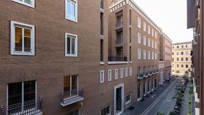 A multi-story building with a brick facade, large windows, and balconies. - Elegant apartment in Via della Frezza, near Piazza di Spagna / Spanish Steps (Rome)