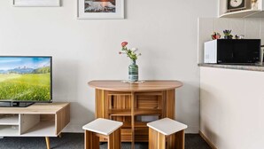 Et moderne køkken med en mikrobølgeovn, et ur og en hylde med pynteting.