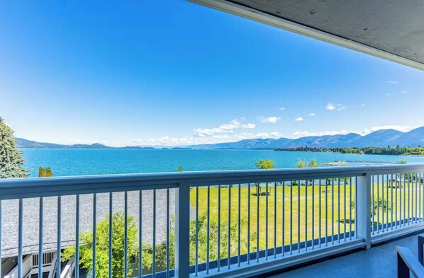 A balcony with a view of a lake and mountains.