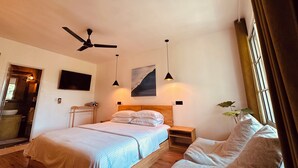 A bedroom with a bed, bedside tables, a ceiling fan, and a window with curtains. - Odi Kamadhoo (Kamadhoo)