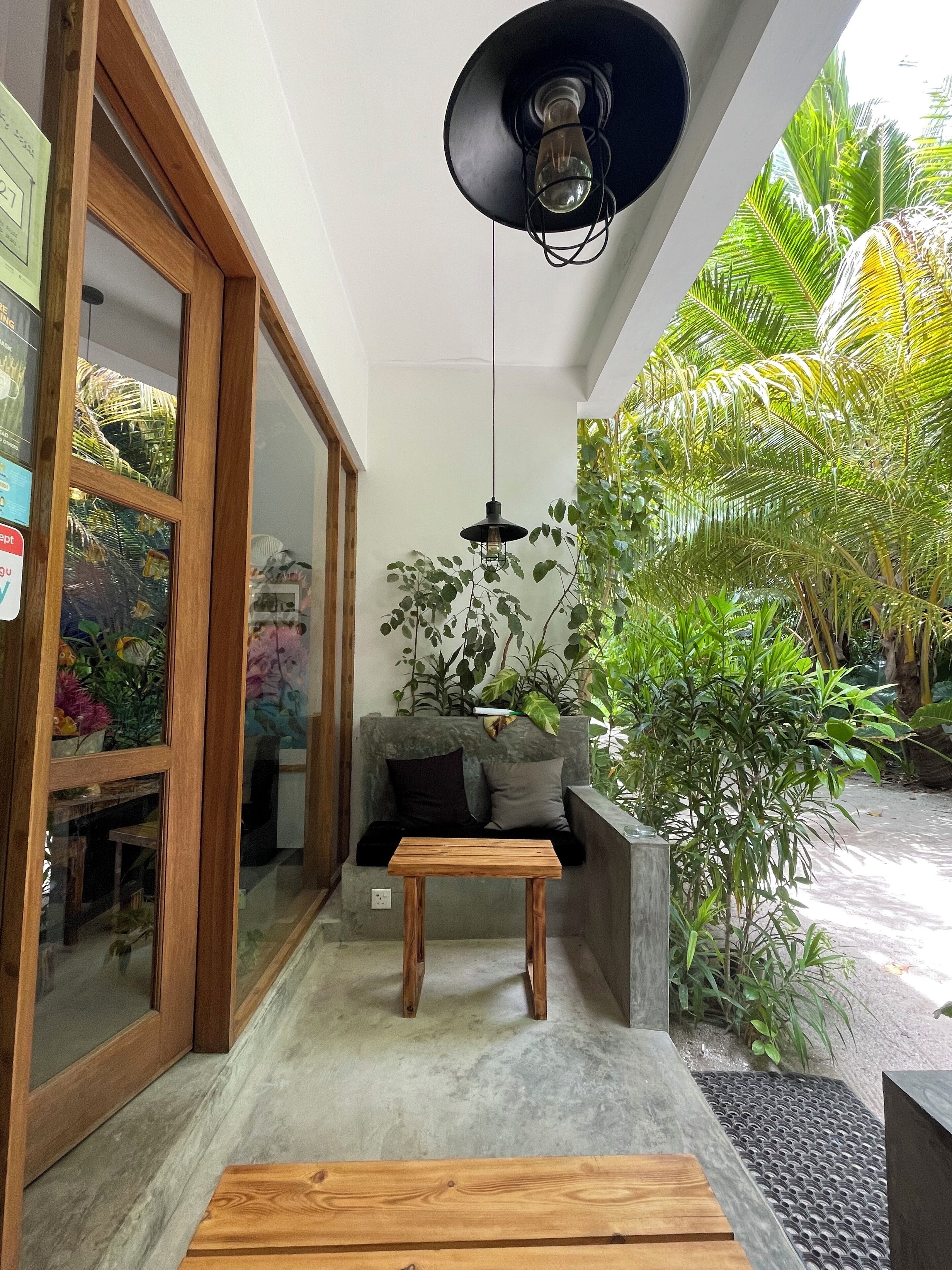 A modern interior with a wooden bench, a table, and a hanging light fixture.
