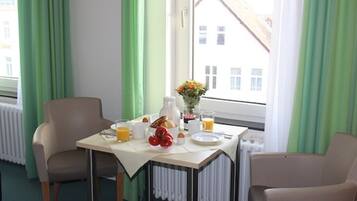 Ein Frühstückstisch mit Stühlen und Blick aus dem Fenster.