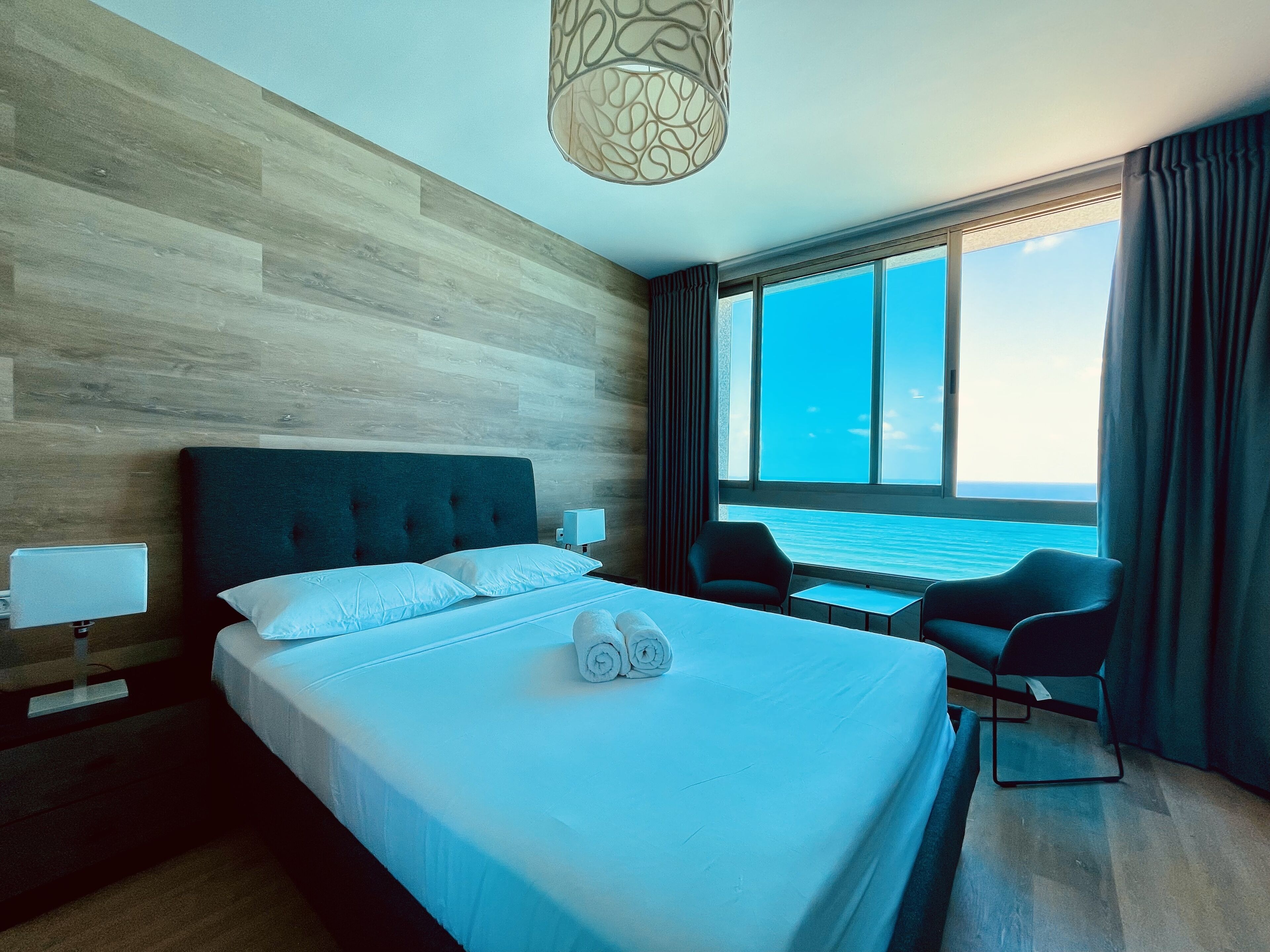 Una camera d'albergo con un letto grande, vista mare e design moderno.