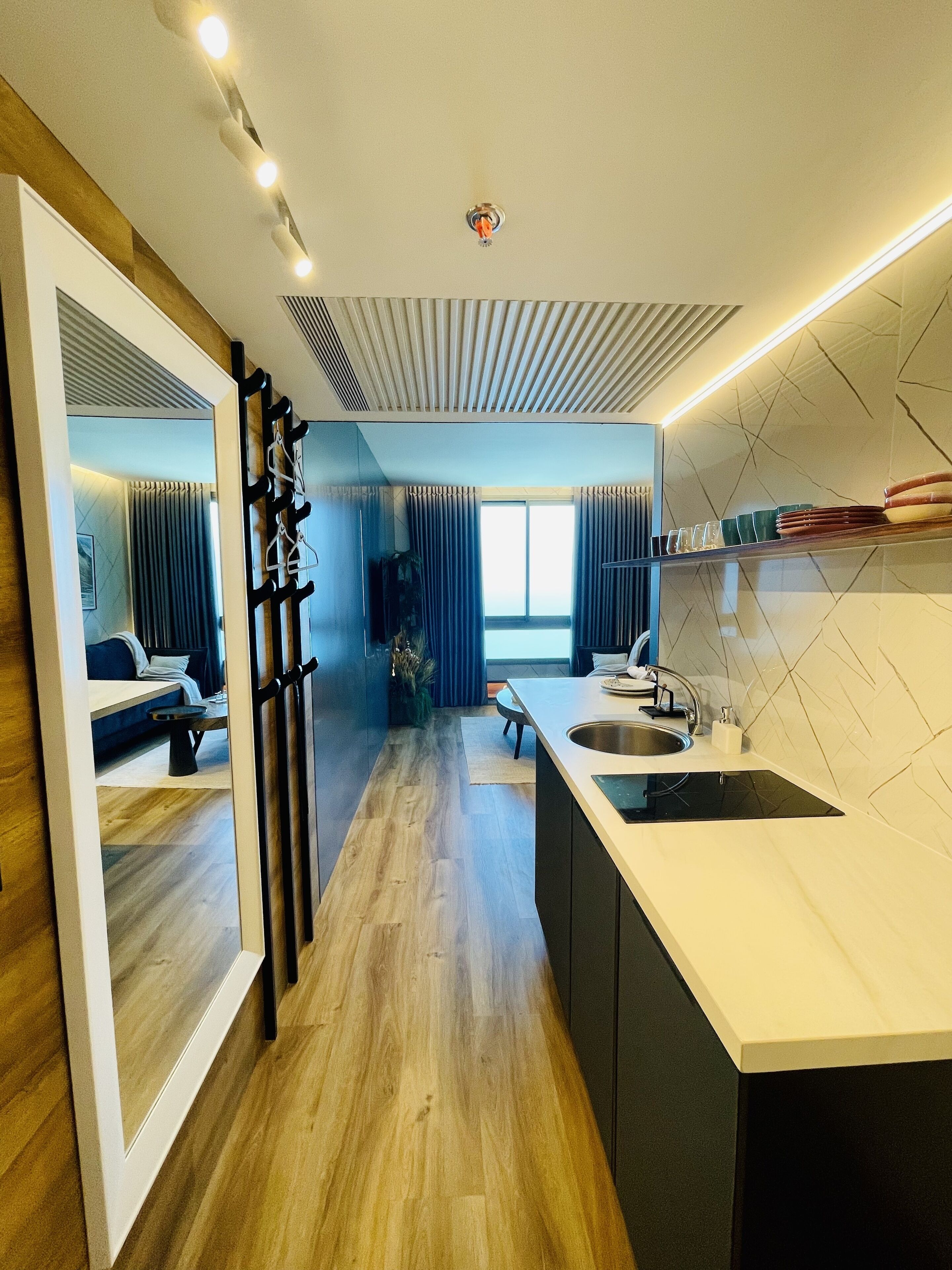 Una cocina moderna con una isla central, un lavamanos integrado y vistas al salón.