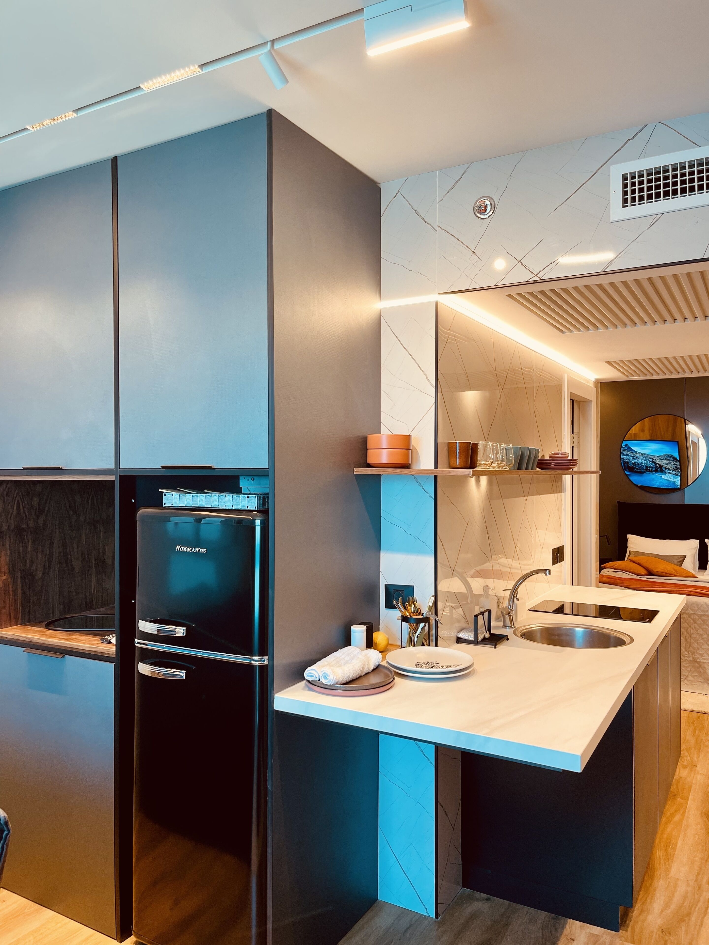 Eine moderne Küche mit Einbaukühlschrank, Spüle und Essbereich mit Fernseher.