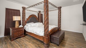 A four-poster bed with a wooden frame and a matching nightstand.